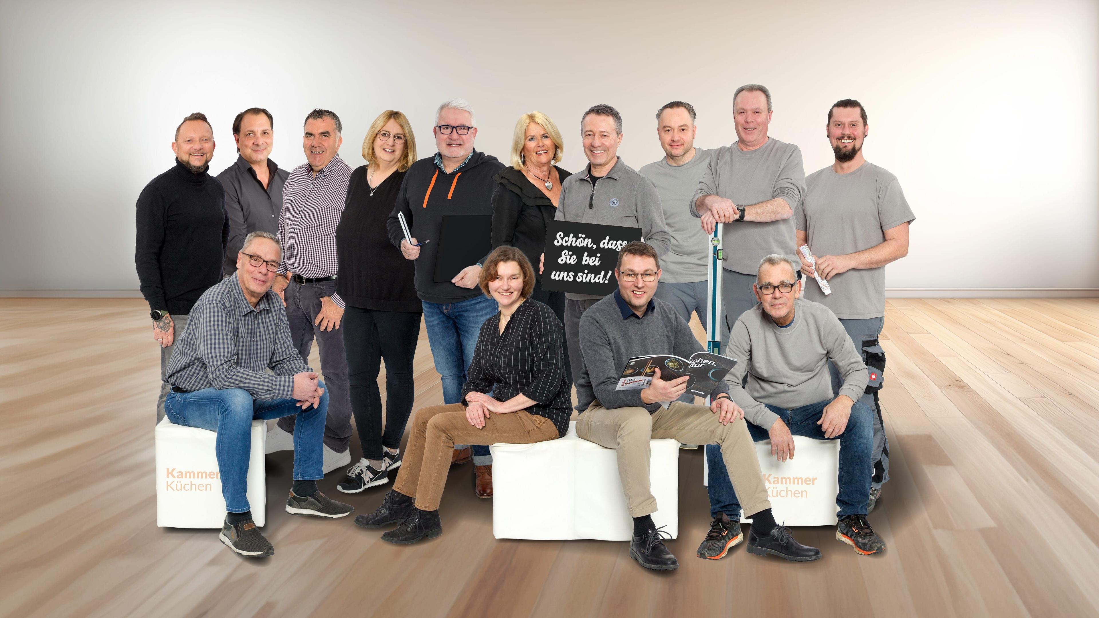 Team von Kammer Küchen – Gruppenbild der Mitarbeiterinnen und Mitarbeiter im hellen Showroom